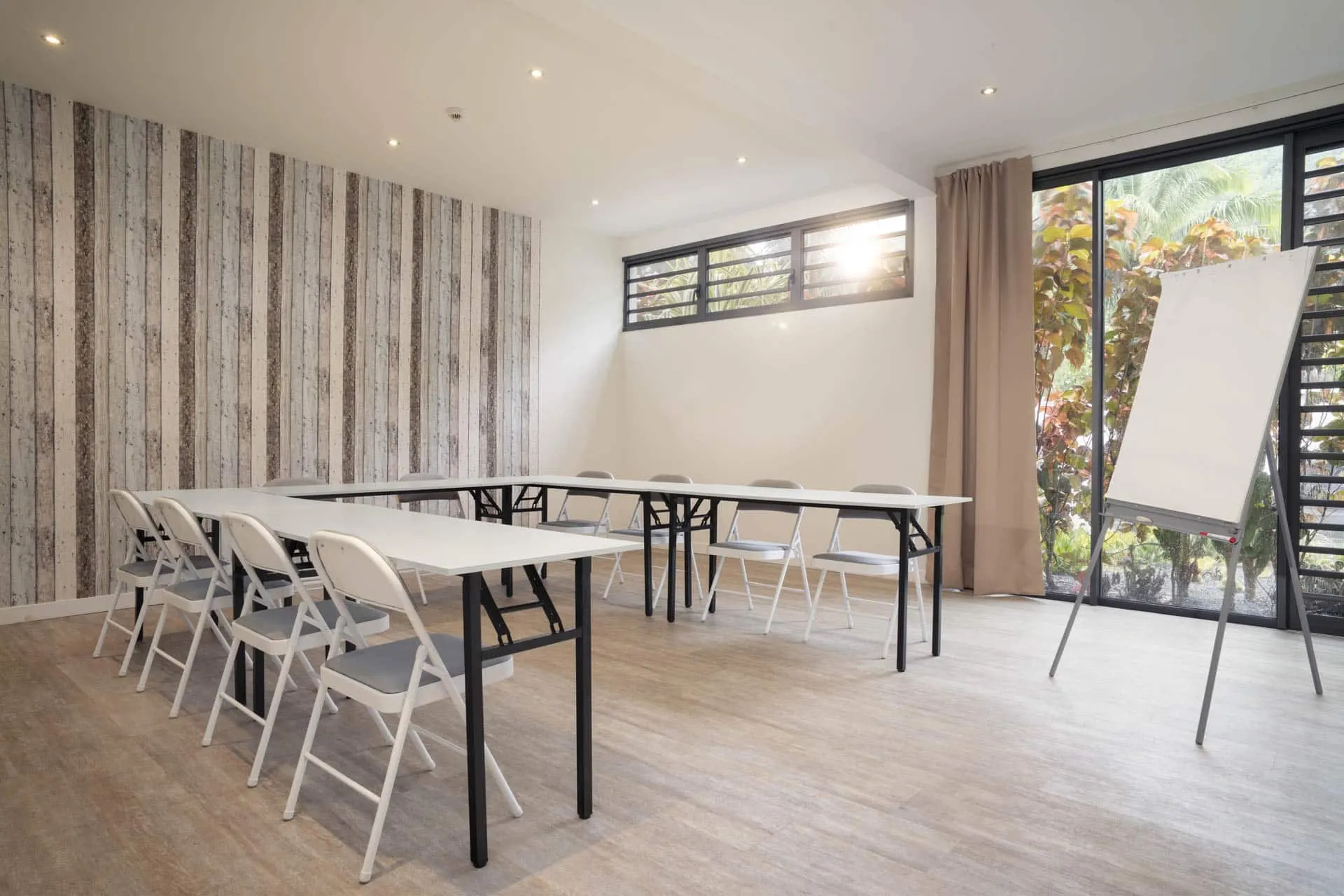 Bright meeting room with tables and flipchart
